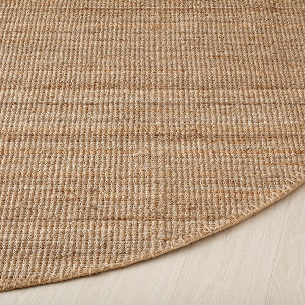 Rustic round rug, tightly woven with natural-toned jute fibres, displaying a durable and textured surface, ideal for cosy and rustic decors.