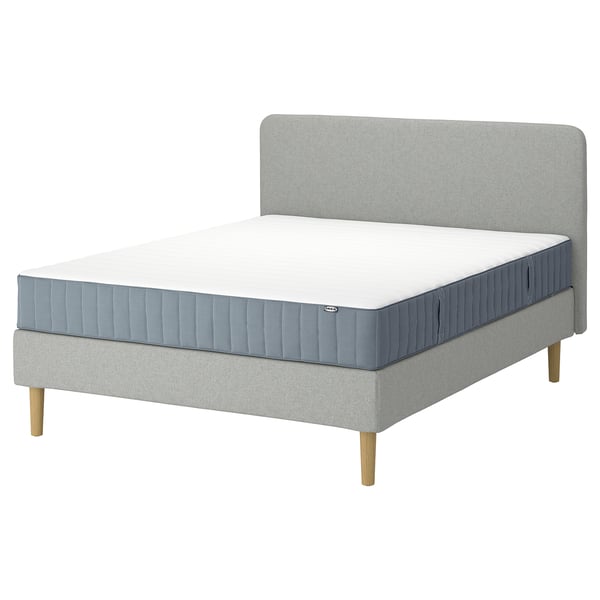 A grey LYNGÖR bed set with a mattress and headboard. The bed has wooden legs and a soft headrest.