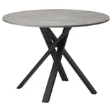 Modern round dining table with grey concrete top and black metal criss-cross legs.