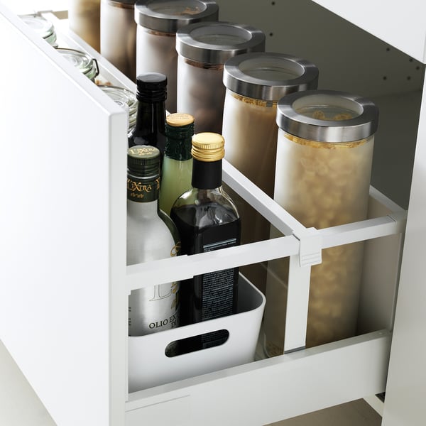 White cabinet drawer with maximised space organisation, showing bottles and containers neatly arranged.