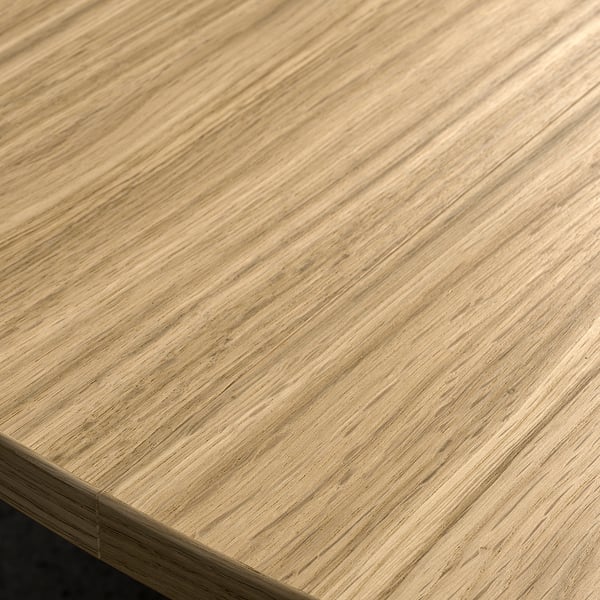 Closer view of light wood table top, smooth grain texture, light brown finish.
