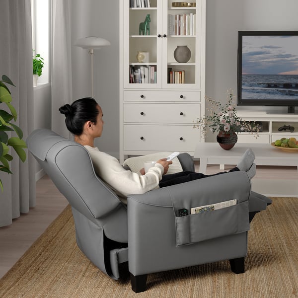 Person relaxing in MUREN recliner, watching tv, with footstool extended.