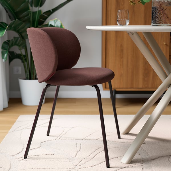Modern upholstered chair with wingback support, metal legs; ideal for comfortable dining.
