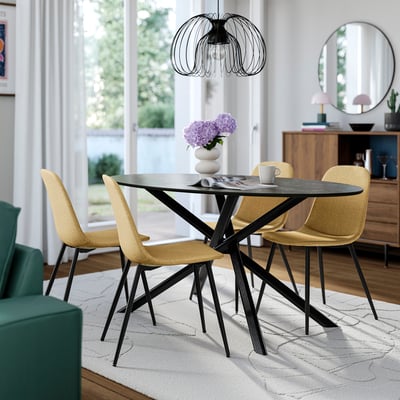 Oval dining table with black metal legs, 4 yellow chairs, rug.