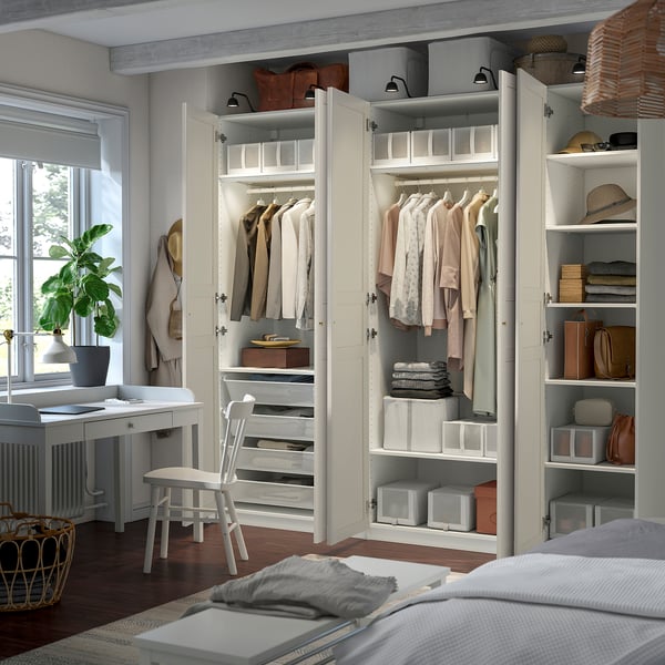 Open wardrobe with clothes, shelves, and drawers. Clothes hang neatly inside with additional storage solutions.