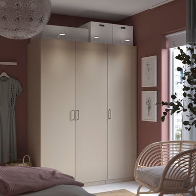 Modern bedroom with beige PAX wardrobe, natural light, stylish decor, and minimalist design.