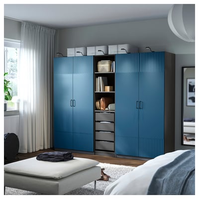 Blue ribbed wardrobe in bedroom, tall with multiple storage options.