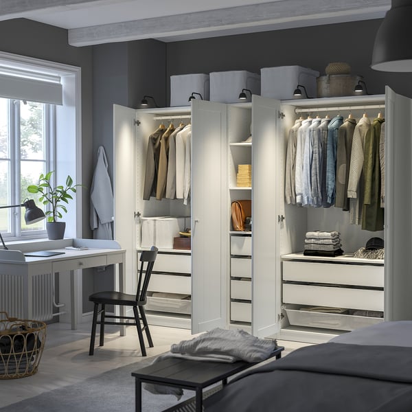 Large wardrobe with clothes and shelves. Bright lighting and organised storage.