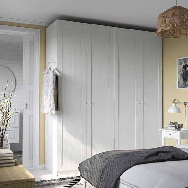 Bedroom large PAX wardrobe, round mirror, wooden bench, and bed with dark blanket. Minimalist, cosy design.