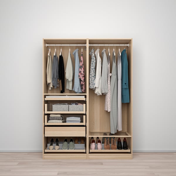 Open wooden wardrobe with hanging clothes, folded items, and shoes, featuring glass organisers and drawers.