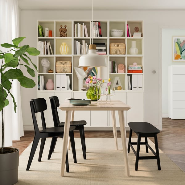 Small black RÄVSTEN rubber wood bench adds modern charm, fits dining spaces, sturdy & compact.