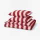 Red and white striped bedding set featuring duvet cover and pillowcases, folded neatly.