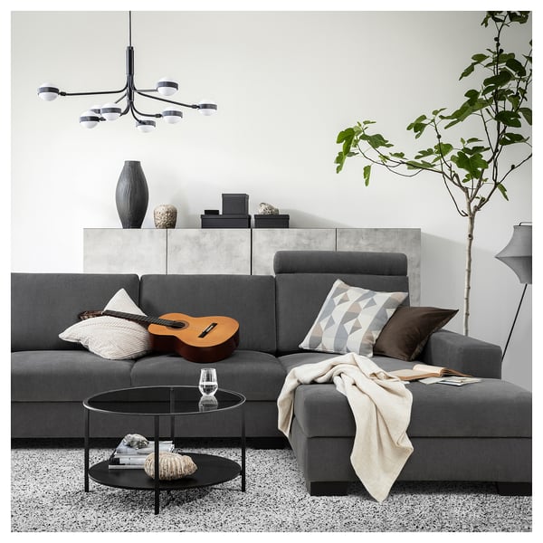 Modern living room with a grey SÖRVALLEN sofa, featuring a coffee table, decor, and pendant lights.