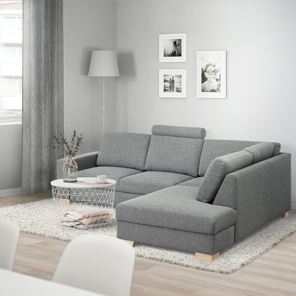Modern living room with SÖRVALLEN grey l-shaped sofa, light coffee table, rug, lamp, and wall art. Sofa is large, fitting well in spacious room.