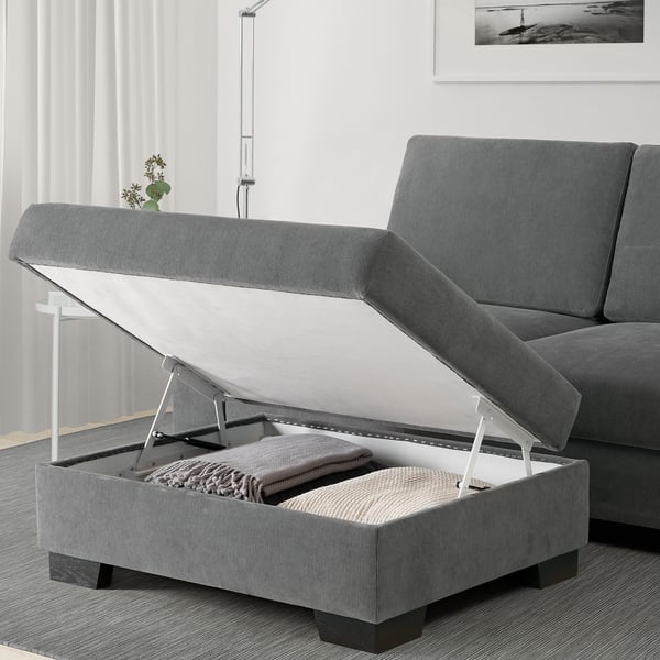 Everyday living room setup featuring grey SÖRVALLEN sofa with open footstool storage revealing blankets.