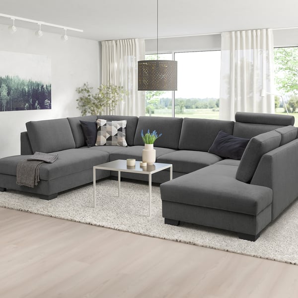 Modern u-shaped grey SÖRVALLEN sofa, large size, light wood floor, white rug, large windows, minimalist decor.