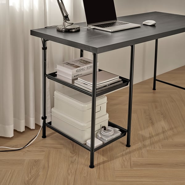 A minimalist desk with shelves, holding a laptop, books, storage boxes, and organising workspace essentials.