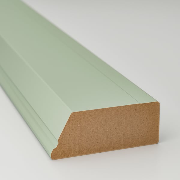 A painted wooden trim, light mint green, smooth finish, slightly angled view.