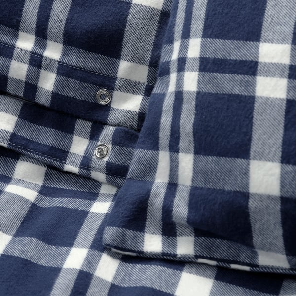 Close-up of navy blue and white plaid flannel fabric, showcasing its soft texture and stitching detail.