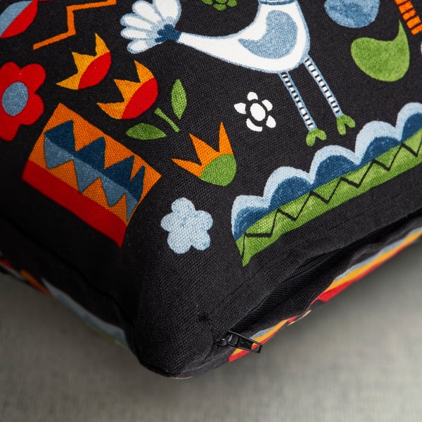 Colourful cushion cover with floral, bird, and human patterns, featuring a hidden zip.