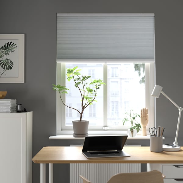 Modern office with TRIPPEVALS blinds, wooden desk, plants, lamp, dark walls, minimalist design.