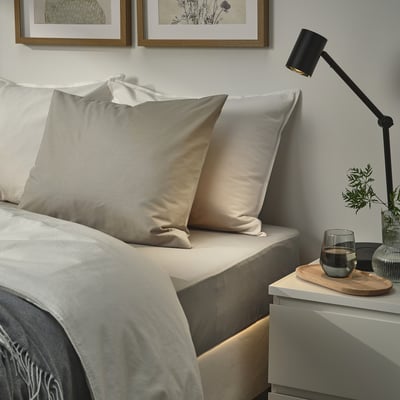 Two beige pillowcases on bed with crisp, smooth texture, envelope closure, cotton and lyocell blend.