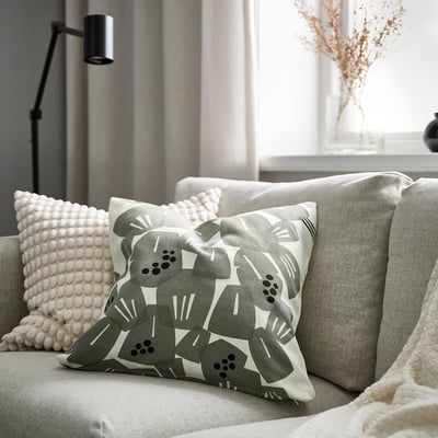 Cosy couch with UNDERBLOMMA pillow and decor.