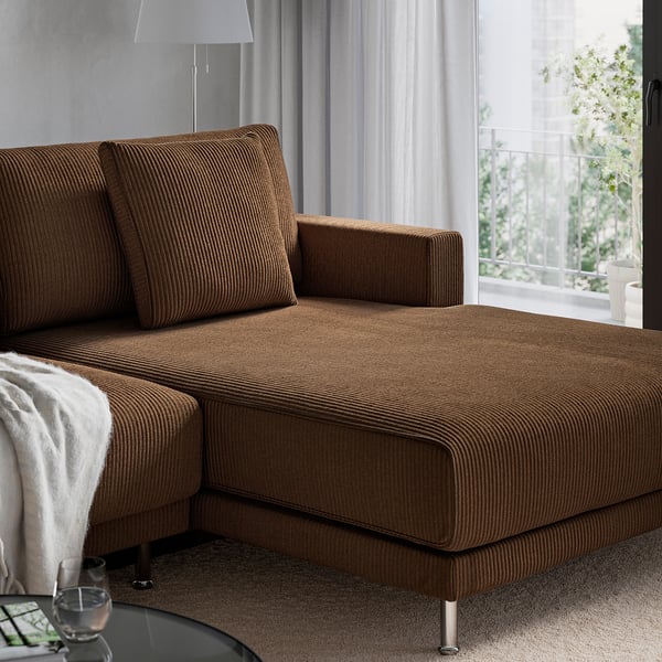 Brown sectional sofa by window, upholstered with striped fabric, offering comfortable seating with cushions. Ideal for family relaxation.