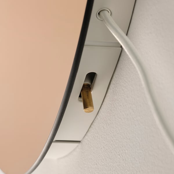 Elegant modern wall sconce with golden bulb holder fixed on a sleek, white frame.