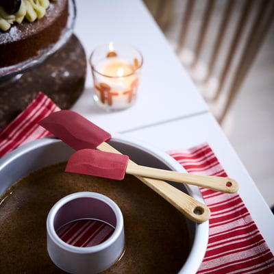 Red spatulas with bamboo handles and baking tools on cloth.