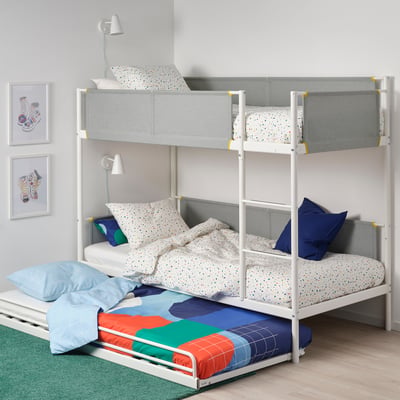 VITVAL bunk bed: white frame, grey upper bed, colourful underbed, fabric guardrails. Cosy, next to grey wall with art, lamp, green rug.