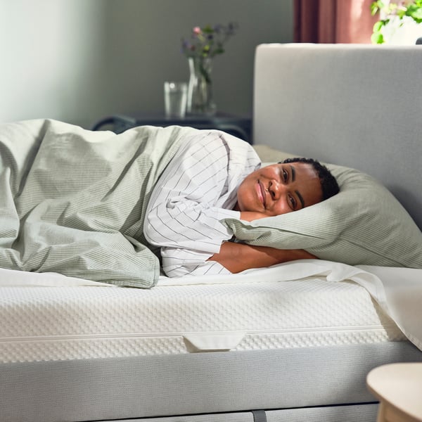Une personne dormant paisiblement sur un matelas blanc åbyzda.