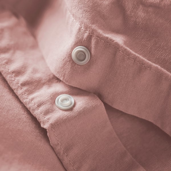 Housse de couette rose avec boutons blancs, en coton naturel pour le confort et la détente.