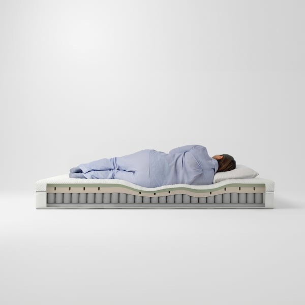 Personne dormant sur un matelas bleu clair avec mousse à mémoire de forme et ressorts ensachés.