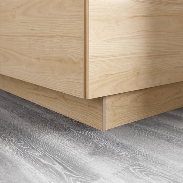 Pied d’armoire en bois, finition frêne clair, surface en mélamine.