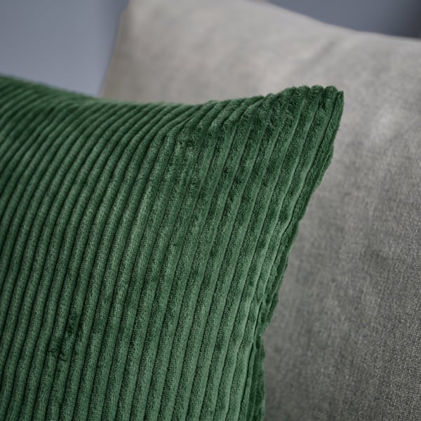 Housse de coussin en velours côtelé vert foncé, douce et durable, avec un motif rayé subtil.