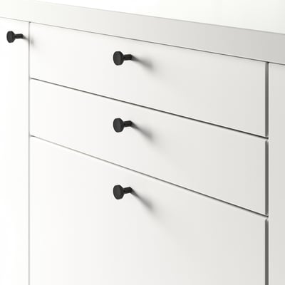 Commode blanche à quatre tiroirs, chacun sécurisé par des boutons noirs, adapté à différentes épaisseurs de porte.