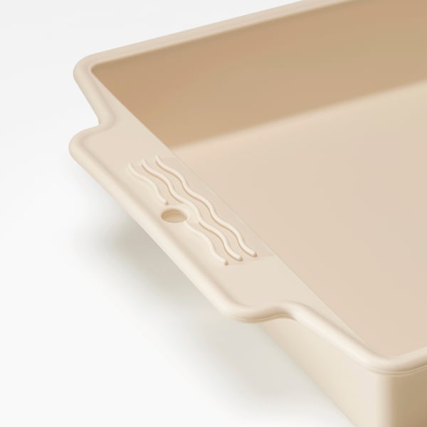 Plaque de cuisson en silicone beige avec poignées faciles à prendre, surface lisse, répartie uniformément de la chaleur.