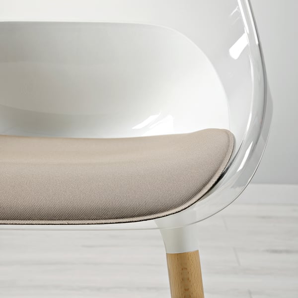 Chaise moderne avec une coque d’assise élégante et transparente, des pieds en bois robustes et un coussin confortable.
