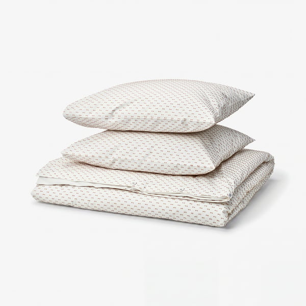 Un ensemble de couette blanc BANDKNIPPE avec des points beiges tissés, en coton doux à 100 %, soigneusement plié.