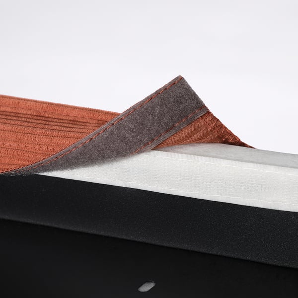 Housse de siège de chaise pliante, orange et gris, affichée sur cadre noir.