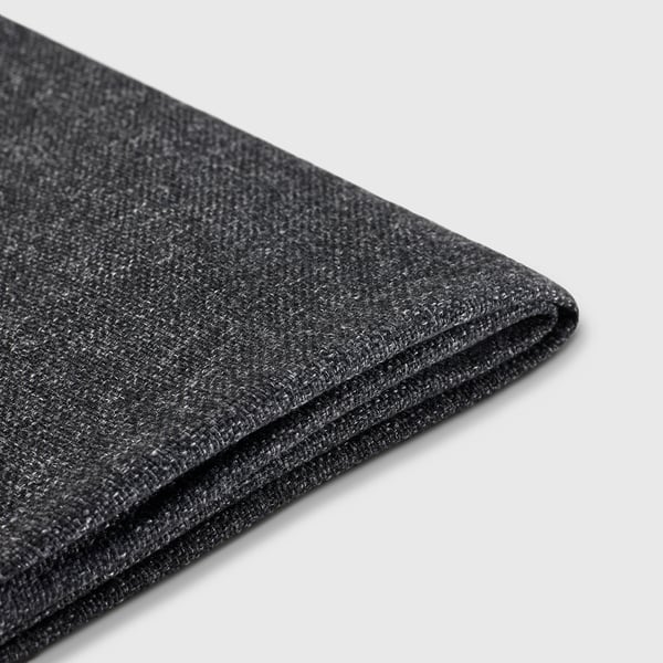 Tissu gris foncé plié, lisse et texturé, probablement un matériau de haute qualité et respectueux de l’environnement.