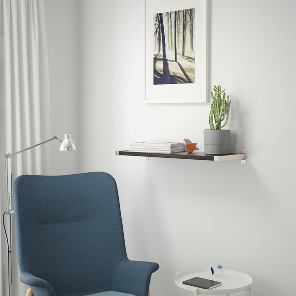 Bureau à domicile minimaliste avec chaise bleue, table ronde, tablette, stylo, étagère avec des livres, cactus et imprimé nature.