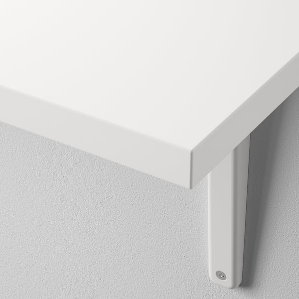 Gros plan de l’étagère murale blanche moderne avec bord lisse, solidement montée contre un mur.