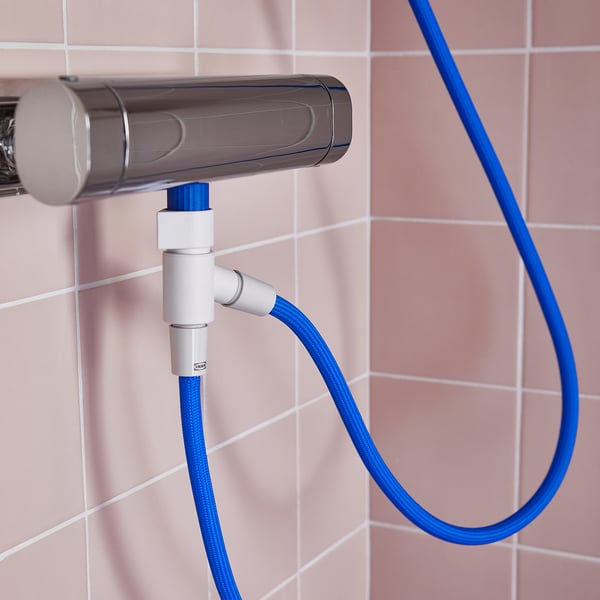 Déviateur de douche argenté avec tuyau bleu attaché. Relié au mur, le tuyau pend librement.