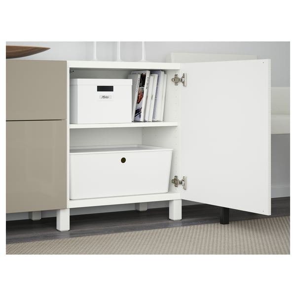 Unité de rangement blanche avec un tiroir ouvert et une étagère, contenant des articles et des livres en boîte blanche.