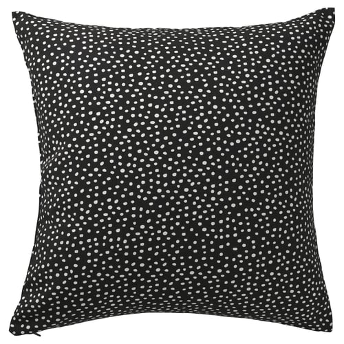 Coussin carré noir à pois blancs, doté d’une fermeture à glissière.