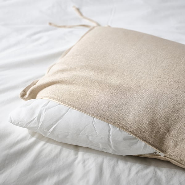 Coussins fixés à la tête de lit, fermeture éclair visible.