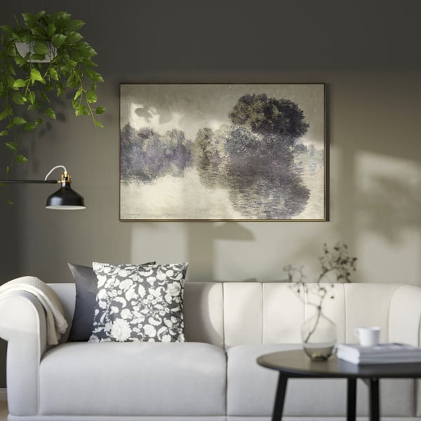 Salon moderne avec des œuvres d’art BLODFLÄDER, un canapé blanc et des plantes.