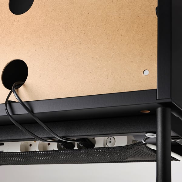 Banc de télévision noir avec portes en verre, filet de gestion des câbles visible en dessous, assurant un rangement organisé et sûr des câbles.
